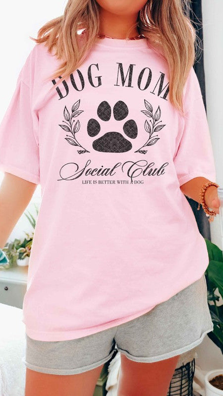 Pink colored Graphic short-sleeved T-shirt on a model that reads "Dog Mom Socal Club".