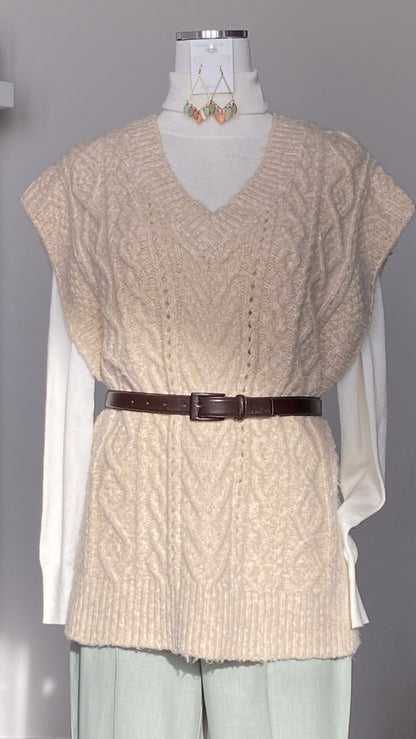 Beige V-neck knitted sweater vest with a brown belt on a mannequin against a gray background